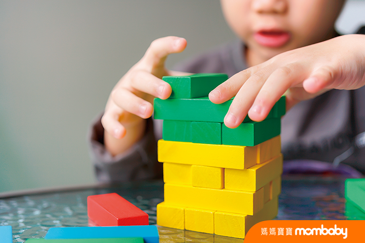 A asian child playing colorful wood blocks stack game, learning and development background concept